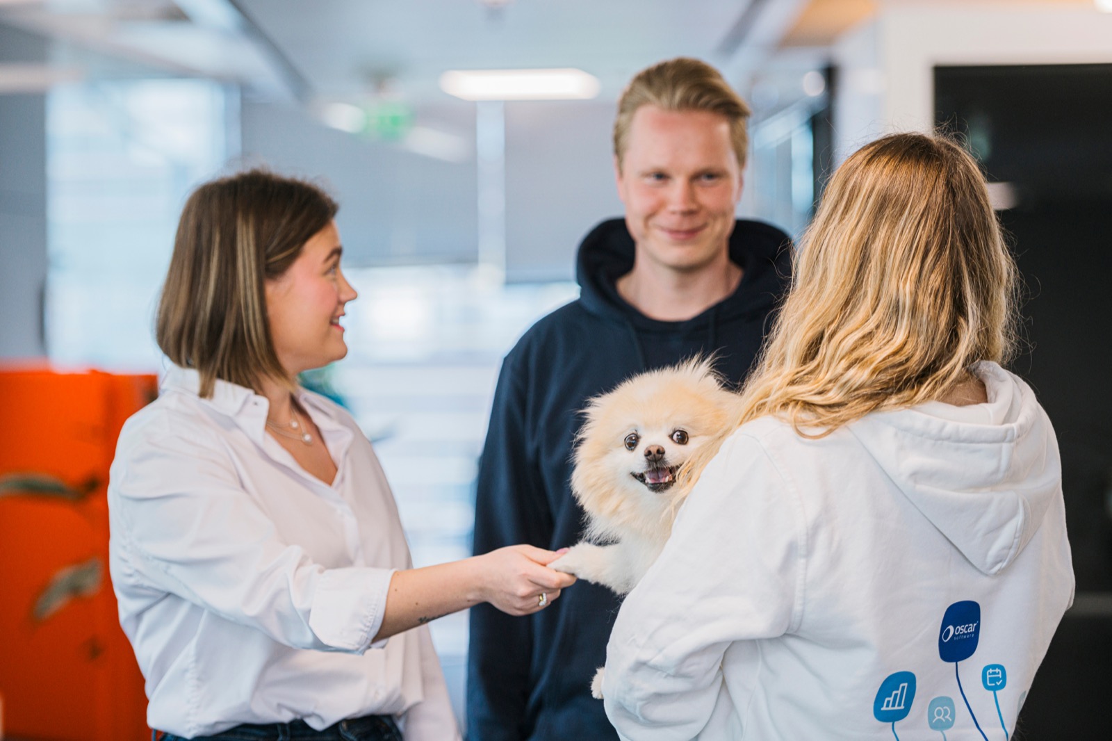 Oscar team member and dog greeting each other